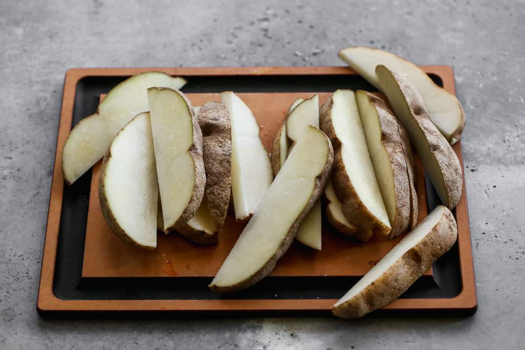 Russet potatoes cut into wedges, to make fries.