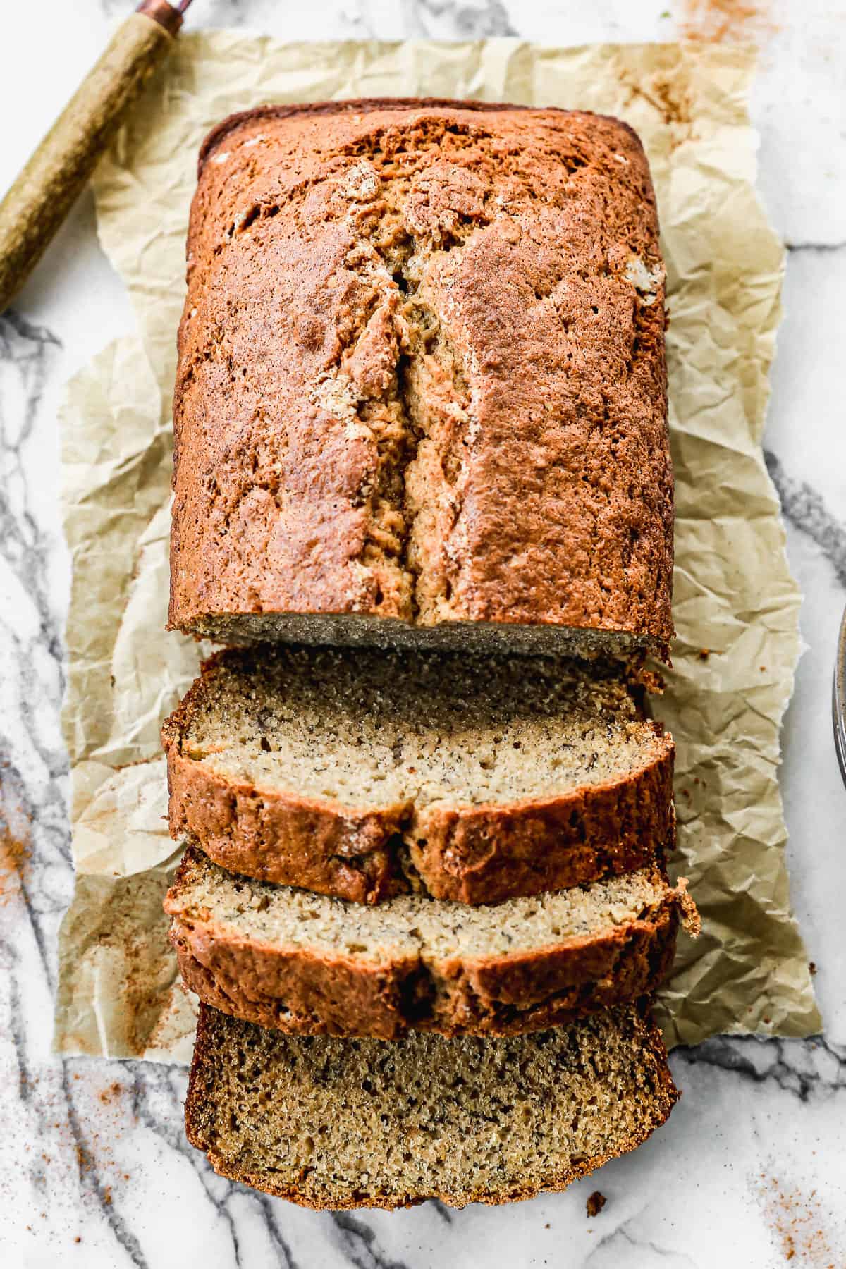 A loaf of homemade Banana Bread with half of it sliced.