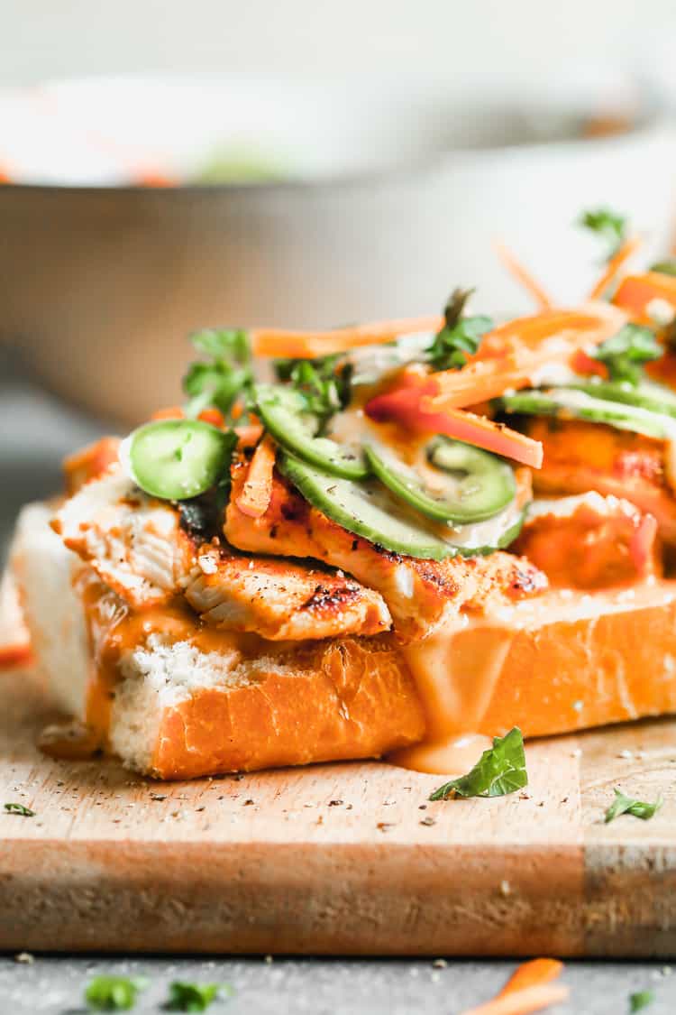 A picture of a banh me inspired sandwich being assembled to show how to make banh mi sandwiches.