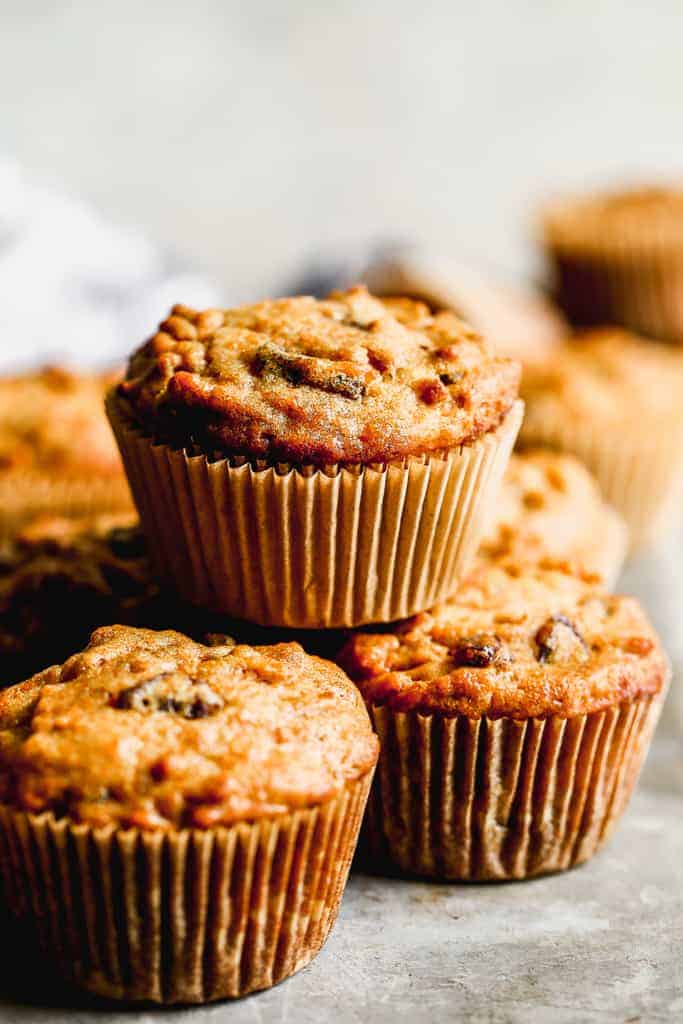 A stack of freshly baked Bran Muffins baked in paper muffin liners.