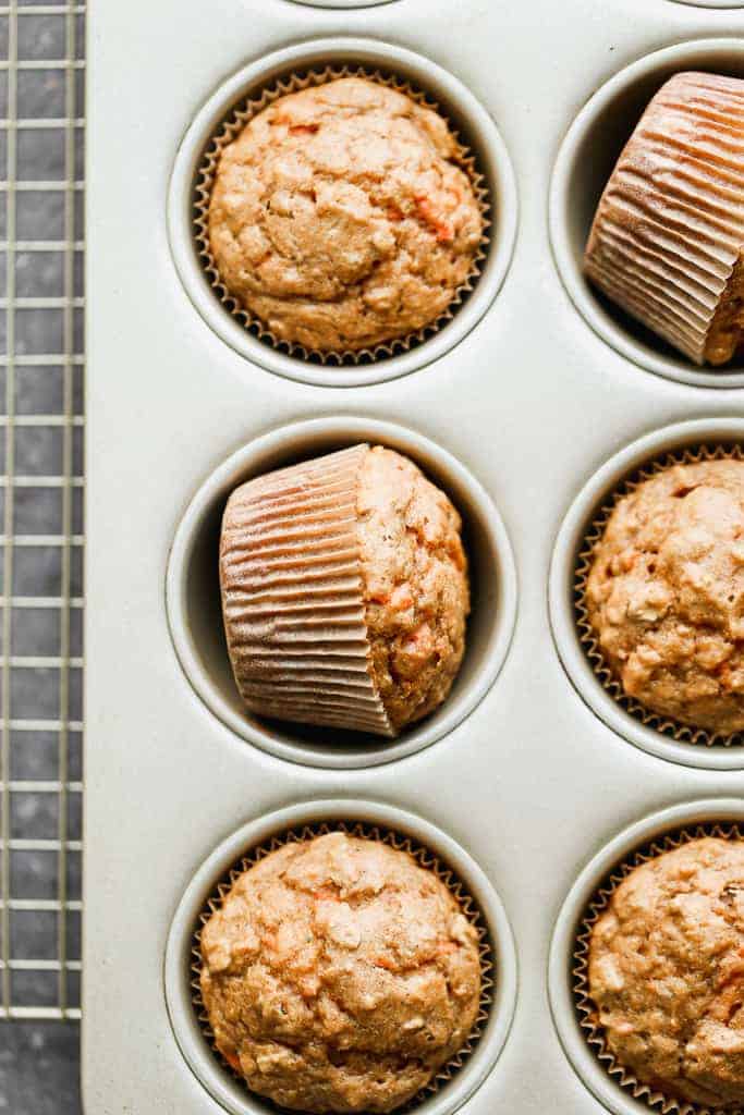 A muffin tin with baked carrot muffins.