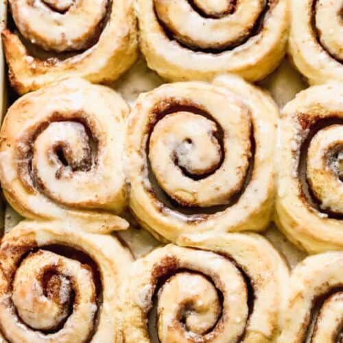 Baked cinnamon rolls on a sheet pan.