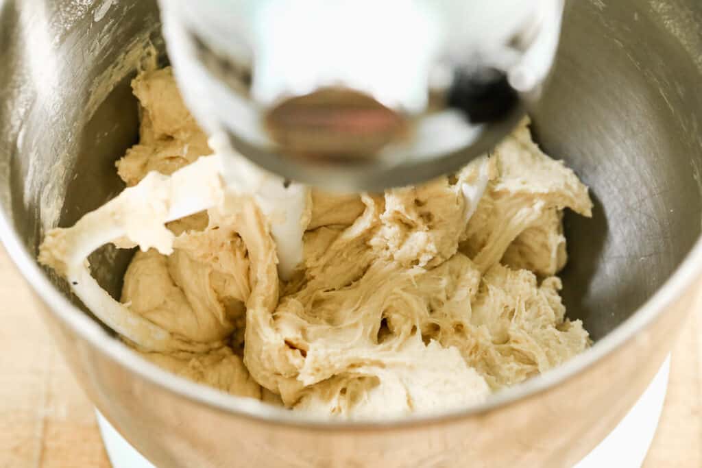 Bread dough being kneaded in a stand mixer.