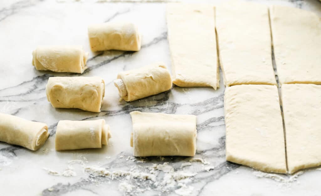 Rolled out dough shaped into homemade rolls.