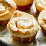 Homemade Orange Rolls on a plate, topped with orange glaze and orange zest.