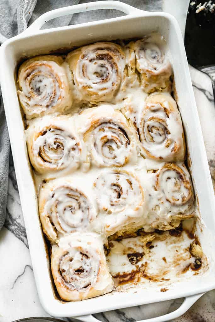 Cinnamon rolls baked in a 11x13 inch pan, with cream cheese frosting on top.