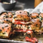 Two easy Pizza Sliders stacked on top of each other on a pan full of Pizza Sliders, ready to serve.