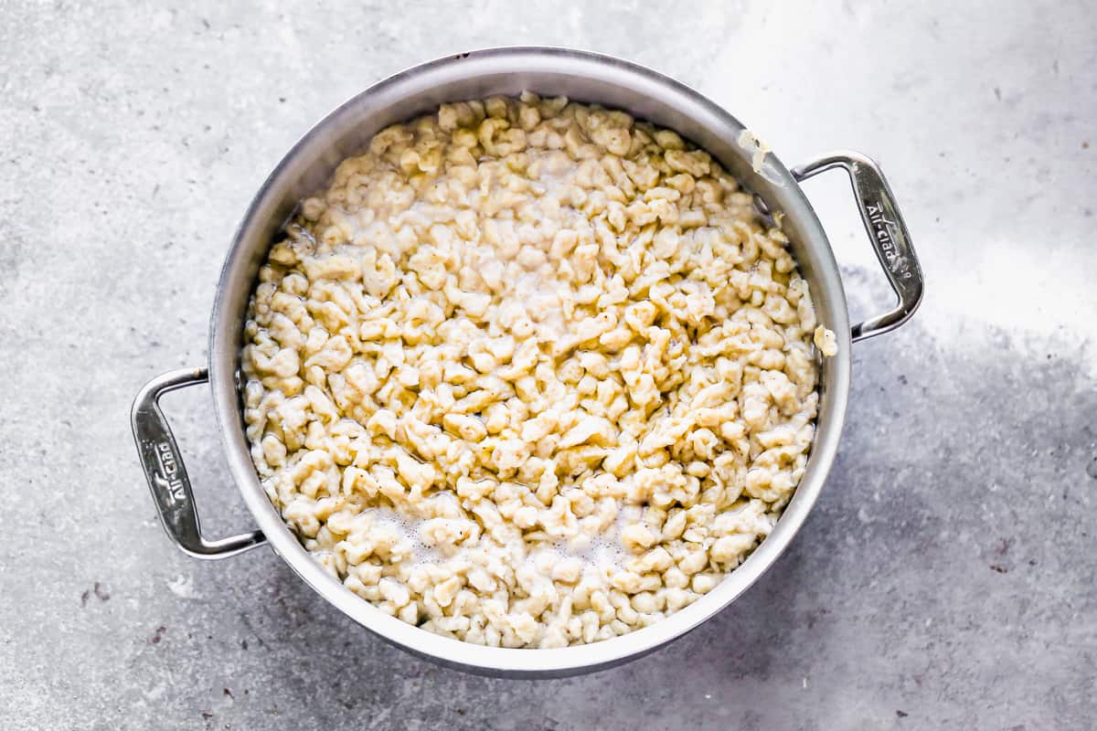 A pot of spaetzle dumplings, floating to the top of the boiled water.