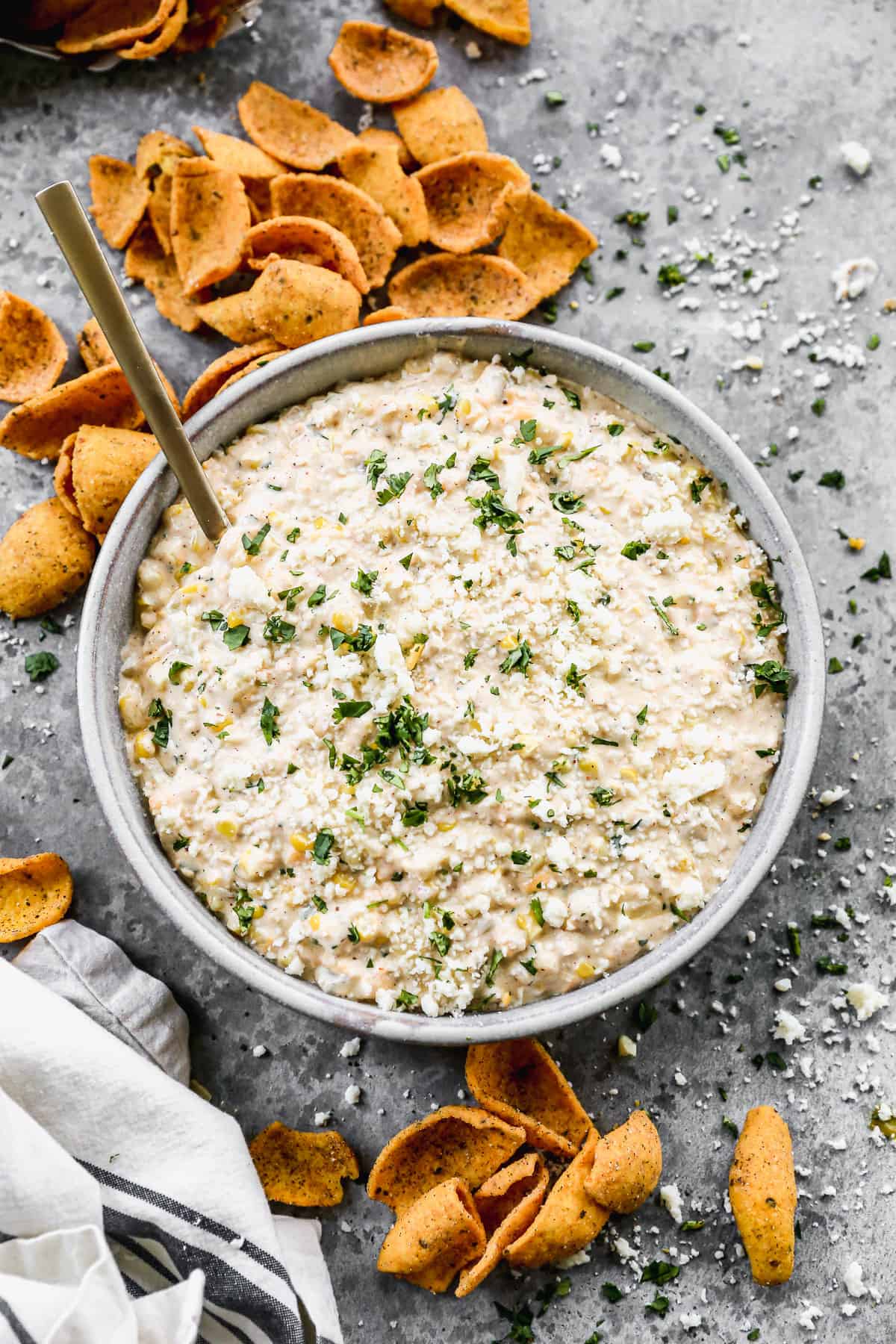 A bowl of easy Street Corn Dip surrounded by chips, ready to serve.