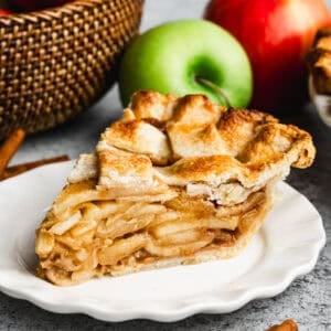 A beautiful slice of an easy Apple Pie recipe with a lattice crust, served on a white plate.