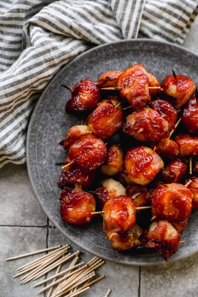 A plate of water chestnuts wrapped in bacon with a delicious glaze, ready to enjoy with toothpicks.