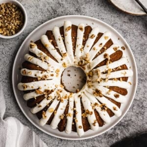 An easy Banana Bundt Cake recipe frosted with cream cheese frosting and sprinkled with chopped walnuts.