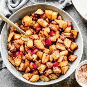 A bowl of crispy Breakfast Potatoes with bell peppers and onion, ready to serve.