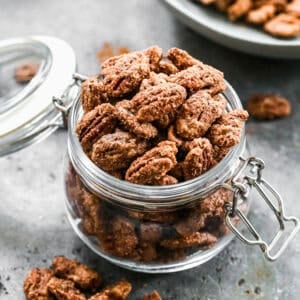 A jar of the best Candied Pecans recipe with a sweet cinnamon sugar coating.