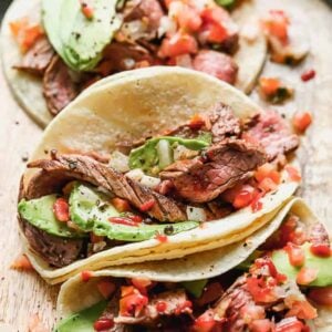 Three Carne Asada Tacos served in corn tortillas topped with pico de gallo and avocado.