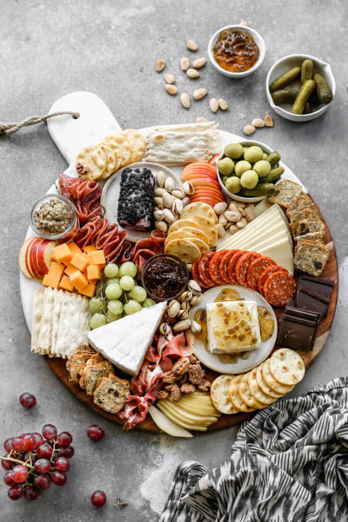 The best charcuterie board with a variety of meats, cheeses, crackers, spreads, and fruit.