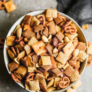 A bowl of homemade Chex Mix with Chex, nuts, pretzels, baked in a simple sauce.