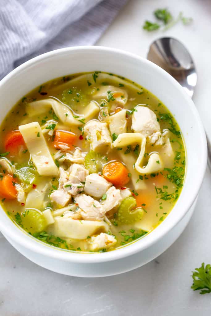 A bowl full of homemade chicken noodle soup, with homemade noodles.