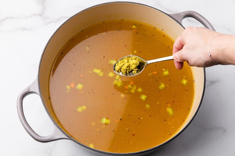 Chicken stock spices and bullion added to a pot to make chicken noodle soup.