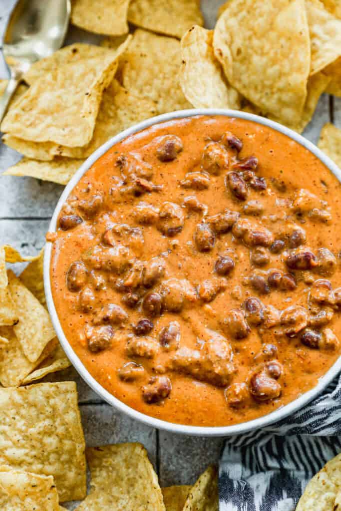 An easy Chili Cheese Dip made with just four ingredients served in a white bowl with tortilla chips.