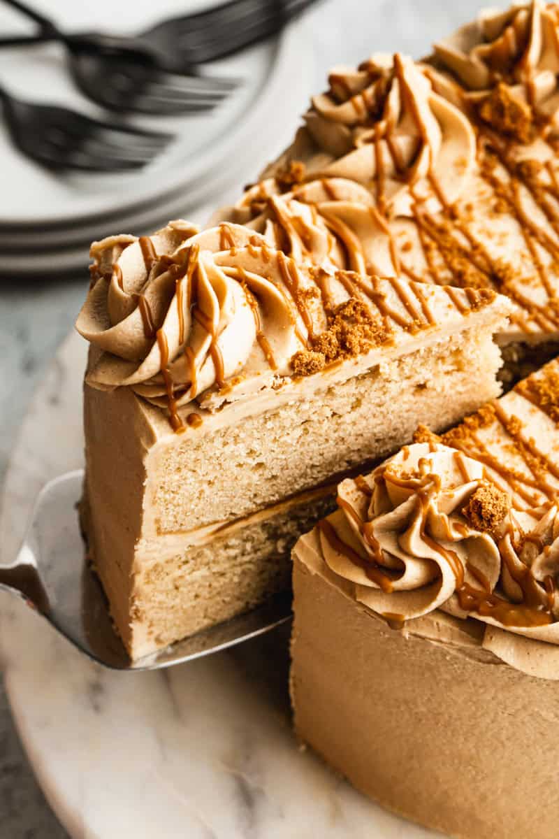 A slice of Cookie Butter Cake being removed to show the moist cake inside. 