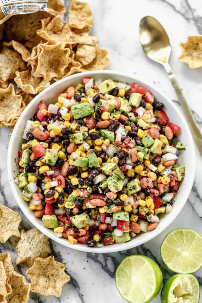 Cowboy caviar dip served in a bowl with chips on the side.