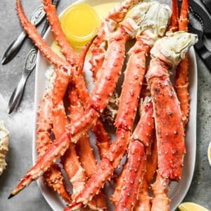 King Crab Legs heated until hot then served on a tray with a cup of melted butter.