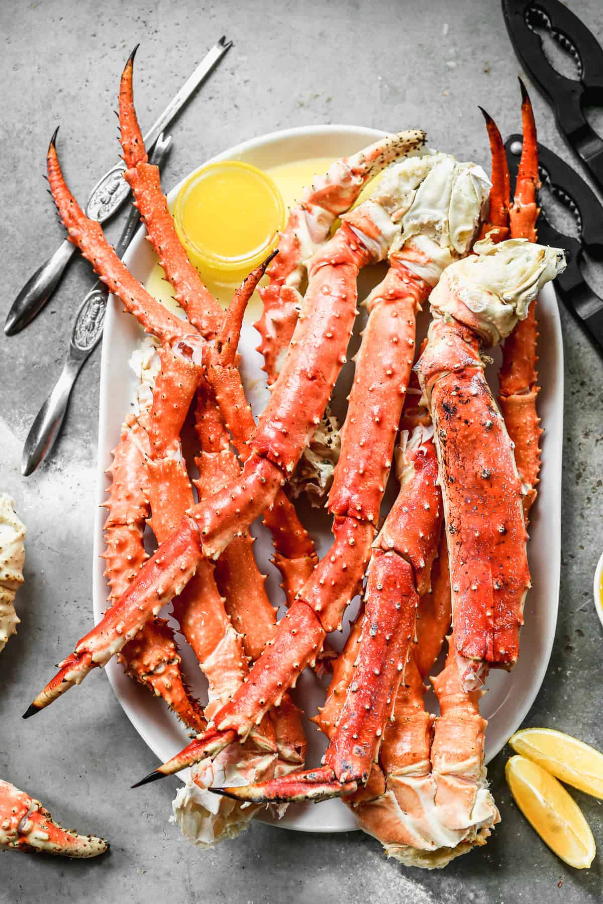 King Crab Legs heated until hot then served on a tray with a cup of melted butter. 