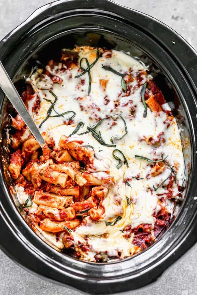 Crock Pot Baked Ziti in a slow cooker with a spoon in it for serving.