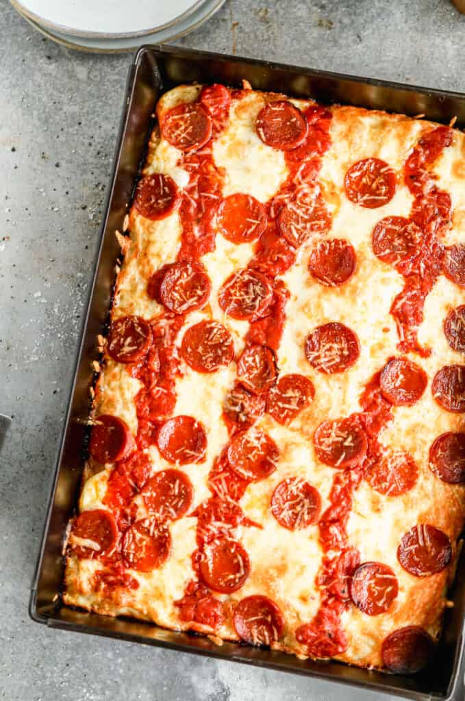 Detroit pizza baked in a steel pan, topped with cheese, sauce and pepperoni.