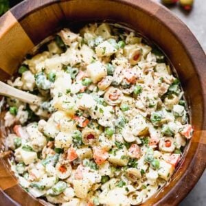 Ensalada Rusa (Russian potato salad) served in a wooden serving bowl.