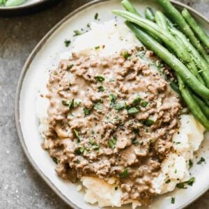 Hamburger Gravy served over mashed potatoes with green beans on the side.