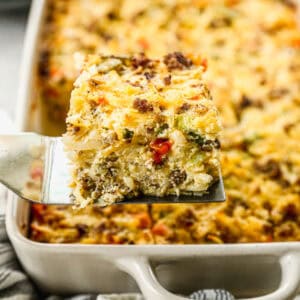 Hashbrown Breakfast Casserole with a slice being removed from the pan.