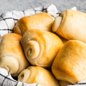 A basket of the best homemade dinner rolls with butter gleaming on top, ready to enjoy.