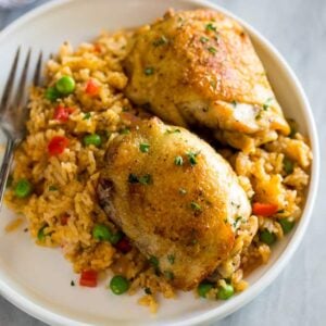 Spanish rice and chicken (arroz con pollo) served on a white plate with a fork.