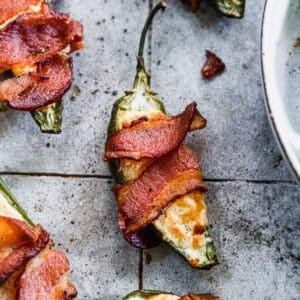 An easy Jalapeño Poppers recipe stuffed with a cream cheese and cheddar cheese mixture then wrapped in crispy bacon.