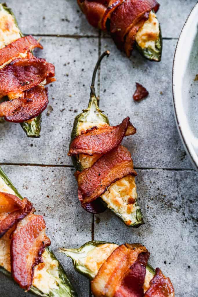 An easy Jalapeño Poppers recipe stuffed with a cream cheese and cheddar cheese mixture then wrapped in crispy bacon.