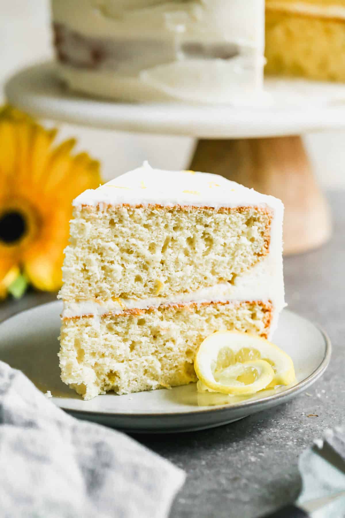 A slice of an easy lemon cake recipe with a homemade lemon buttercream frosting.