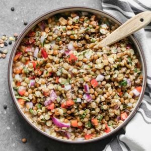 Lentil Salad in a serving bowl with a wooden spoon.