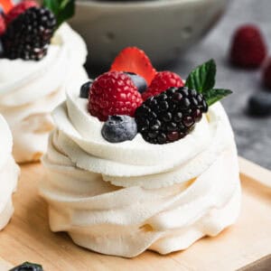 An easy Pavlova recipe made into individual mini pavlovas, topped with whipped crema and fresh berries.