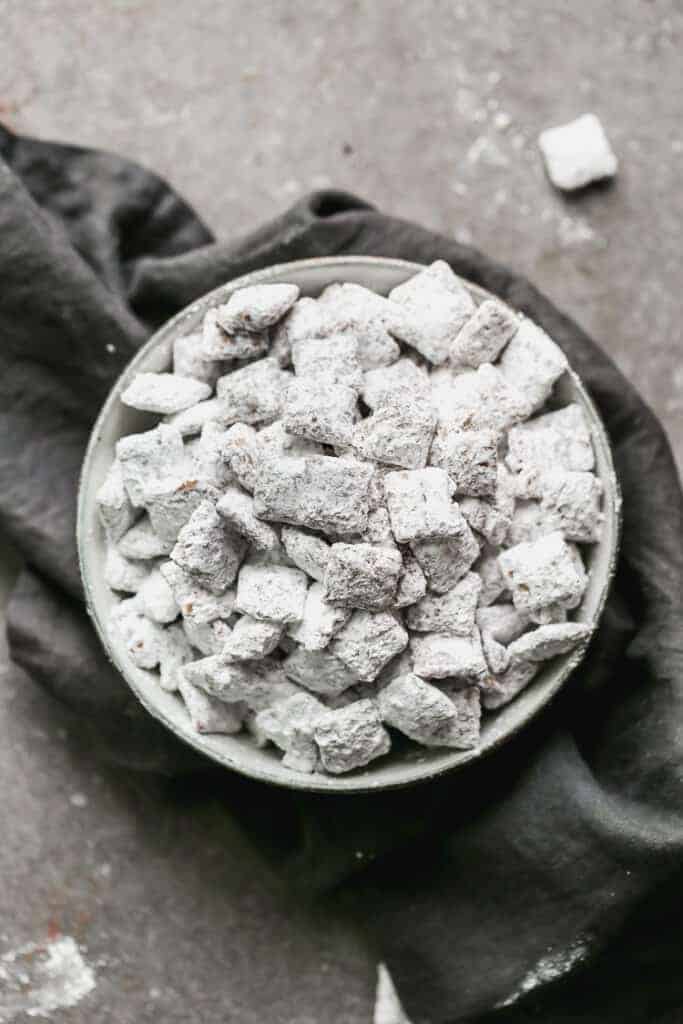 A bowl of muddy buddies (puppy chow) on a grey towel.