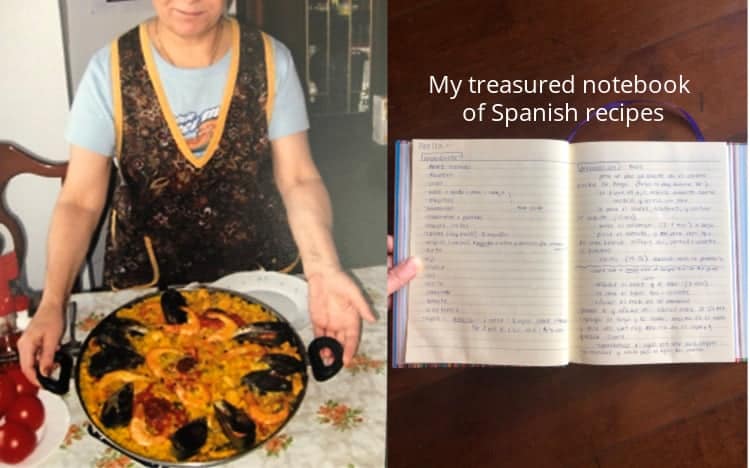 A Madrileña holding a pan of paella, next to a notebook with the a paella recipe written in Spanish.