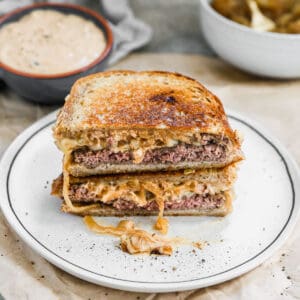 The best Patty Melt on sourdough bread, cut in half and stacked on top, ready to eat.