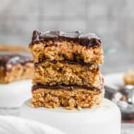 Three chewy peanut butter bars stacked on top of each other.