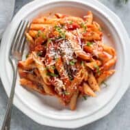 A white plate full of Italian penne arrabbiata.