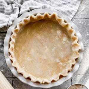 An easy Pie Crust recipe with fluted edges inside a pie dish, waiting to be pre-baked or filled.