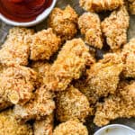 A pan of homemade popcorn chicken, crispy and ready to be served with a dipping sauce.