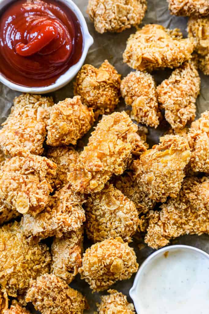 A pan of homemade popcorn chicken, crispy and ready to be served with a dipping sauce.