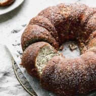 Poppy seed cake with a few slices cut into it.