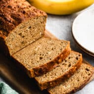 A loaf of a high protein banana bread recipe with a few slices cut and ready to enjoy.